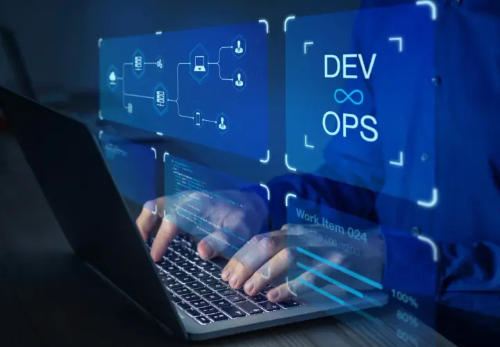 Ręce programisty pracującego na laptopie, wizualizacja zastosowania chmury obliczeniowej i DevOps.
