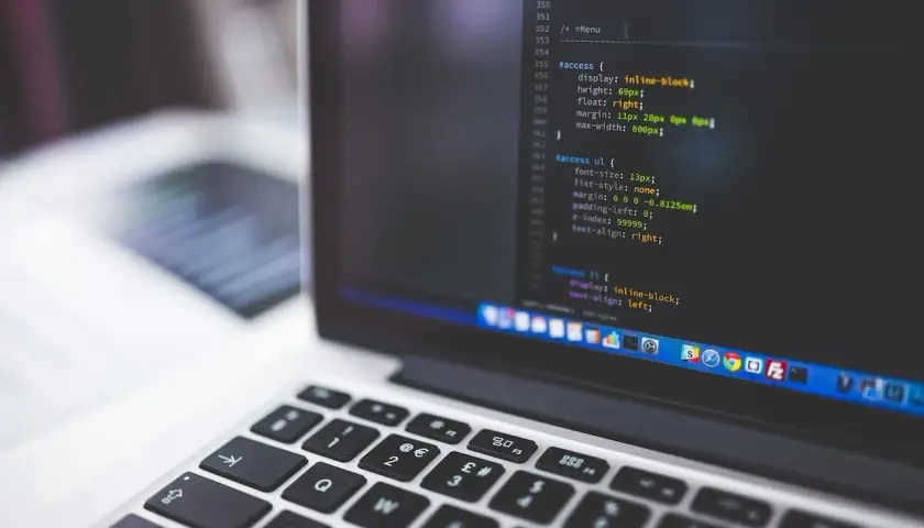 Klawiatura laptopa z kodem w Visual Studio Code. Odkryj efektywne **visual studio code skróty klawiszowe**, by przyspieszyć pracę.